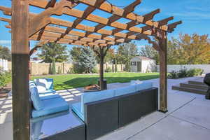Fenced backyard featuring a pergola, an outdoor living space, a patio area, and a shed
