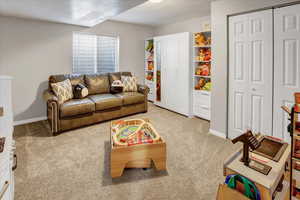 Bedroom with light carpet and a textured ceiling.