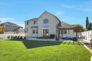 Back of property with a patio area, a fenced backyard, stucco siding, an outdoor hangout area, and roof with shingles.