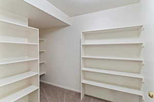 The spacious walk-in closet off the primary bedroom offers ample storage with room for all your wardrobe essentials. Thoughtfully designed for organization and ease, it provides a private, functional retreat complete with built-in shelving and hanging spa