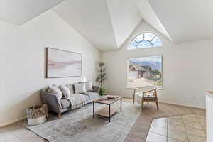 Elegant formal living room features soaring vaulted ceilings and a large window that floods the space with natural light. Seamlessly connected to the formal dining area, this inviting space offers a perfect blend of grandeur and comfort—ideal for entert