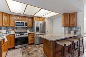 This well-appointed kitchen is both stylish and functional, featuring a spacious pantry for extra storage, all appliances included for move-in ease, and a convenient breakfast bar perfect for casual dining or entertaining. The open layout offers a seamles