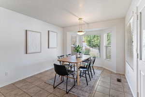 The bright semi-formal dining area offers the perfect balance of casual comfort and refined style. Thoughtfully positioned by the kitchen and family room, it provides an ideal space for both everyday meals and entertaining. Large windows bring in abundant