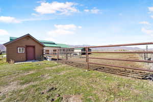 View of yard with an outdoor structure, a mountain view, and an exterior structure