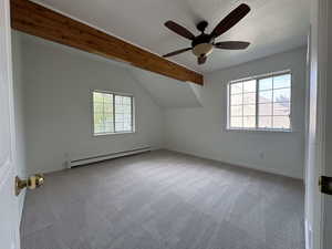 Additional living space with light carpet, baseboard heating, healthy amount of natural light, and a ceiling fan
