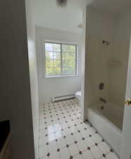 Full bath with shower / bath combination, light floors, and baseboard heating