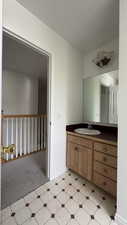 Bathroom with vanity, light floors, and light colored carpet