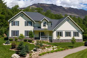 View of front of home with a porch, a mountain view, stone siding, a shingled roof, and a front yard. AI generated image with trees removed