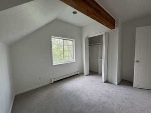 Unfurnished bedroom with a baseboard radiator, carpet floors, a closet, and a textured ceiling