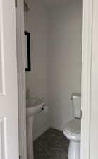 Bathroom featuring baseboards and toilet