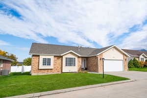 Ranch-style home featuring concrete driveway, brick siding, and a shingled roof