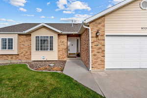 View of front of home featuring brick siding, a shingled roof, a garage, and a front yard