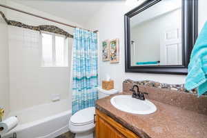 Full bathroom featuring shower / bath combination with curtain and vanity