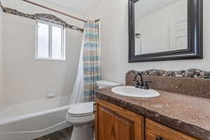 Bathroom featuring vanity and shower / bath combination with curtain