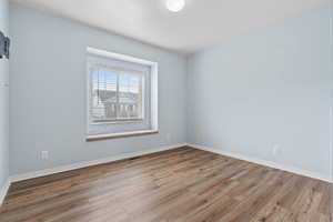 Spare room featuring light wood-style floors and a textured ceiling