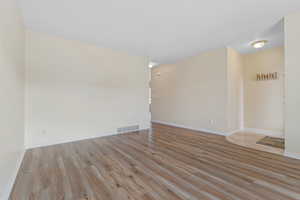 Spare room featuring light wood finished floors and baseboards