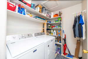 Laundry area featuring washing machine and clothes dryer and attic access. Washer and dryer not included in the sale of the home
