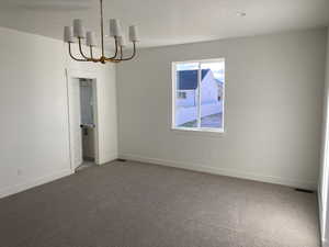 Unfurnished dining area featuring a chandelier and carpet floors