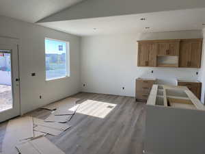 Kitchen featuring wood finished floors, brown cabinetry, and a textured ceiling