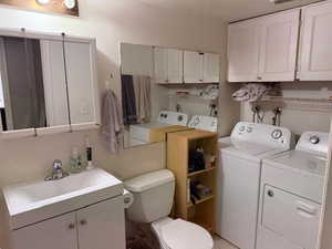 Bathroom featuring vanity and washer and clothes dryer