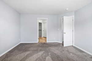 Unfurnished bedroom featuring carpet floors and baseboards