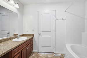 Bathroom featuring vanity, tub / shower combination, and light tile patterned floors