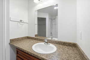 Full bathroom featuring vanity, shower / bath combination, and a spacious closet