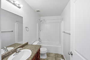Bathroom with vanity, shower / bath combination, and light tile patterned flooring