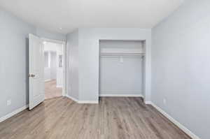 Unfurnished bedroom with light wood-style floors and a closet