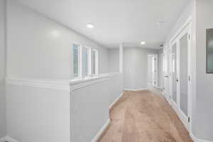 Corridor featuring carpet floors, electric panel, and recessed lighting