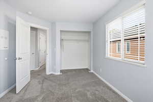 Unfurnished bedroom with carpet flooring and a closet