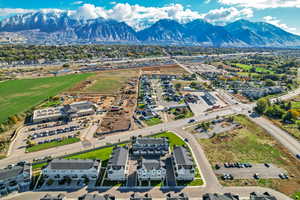 Aerial view of property and surrounding area featuring mountains and nearby suburban area