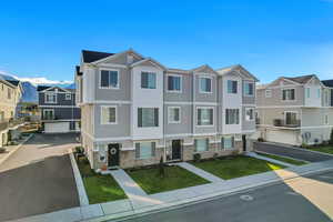 View of front of property featuring a residential view, a front lawn, brick siding, and stucco siding