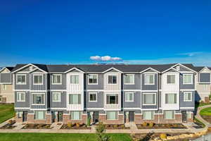 View of front of property with a residential view, board and batten siding, and brick siding