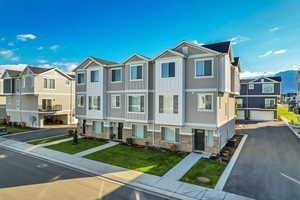View of front of home featuring a residential view, board and batten siding, a front lawn, and brick siding