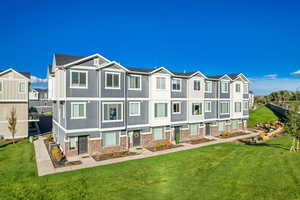 Rear view of property with a residential view, a lawn, and brick siding