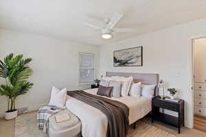 Bedroom with ceiling fan and a textured ceiling