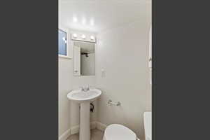 Bathroom featuring toilet and baseboards