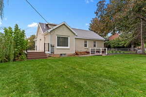 Rear view of property with a deck and roof with shingles