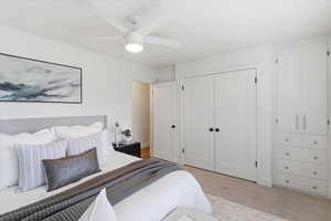 Bedroom featuring light colored carpet, a closet, and a ceiling fan