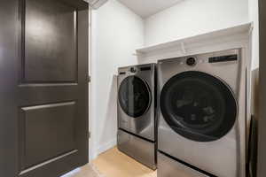 Laundry area with light tile patterned floors and independent washer and dryer