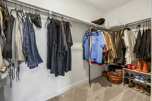 Spacious walk-in closet off main bedroom, featuring carpet