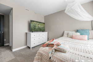 Bedroom featuring light carpet and walk-in closet