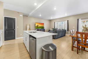 Kitchen featuring white cabinetry, stainless steel dishwasher, light wood-type flooring, and recessed lighting