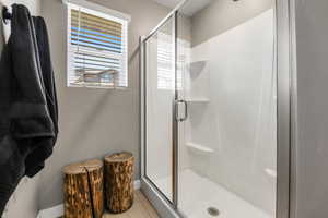 Full bath with a large shower and light wood-style flooring