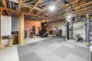Unfinished basement used as an Exercise area, homes electric panel, utility room and concrete floors