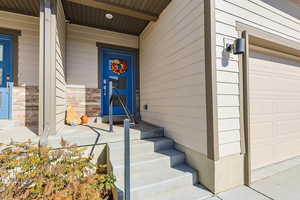 Entrance to property featuring a garage and siding