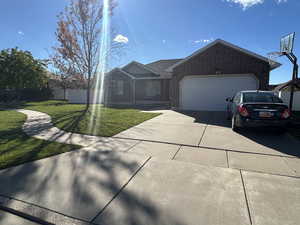 Ranch-style home with brick siding, concrete driveway, and an attached garage