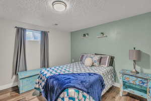 Bedroom featuring wood finished floors and a textured ceiling