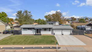 Traditional-style house featuring concrete driveway, brick siding, roof with shingles, and an attached garage